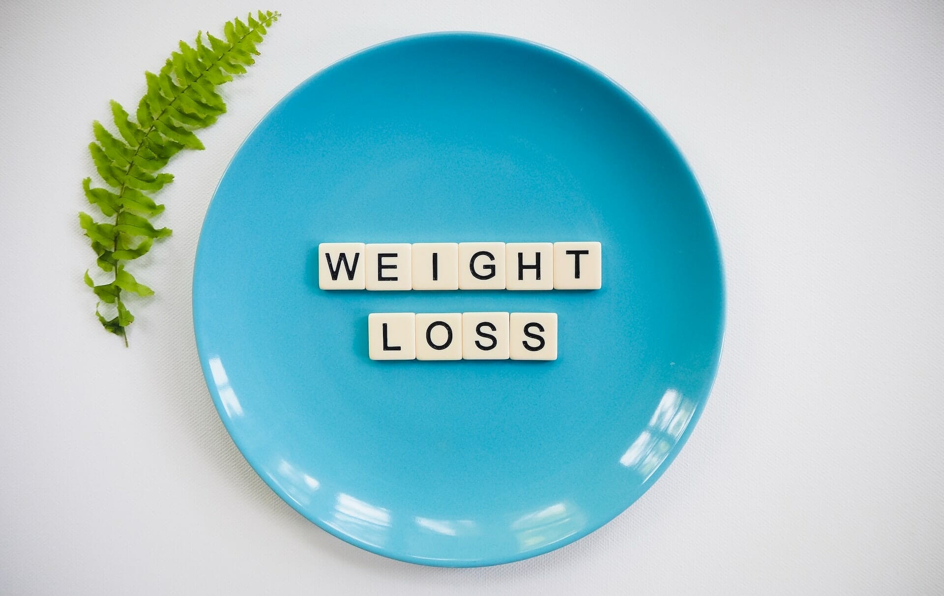 Scrabble pieces spell out "weight loss" on a plate