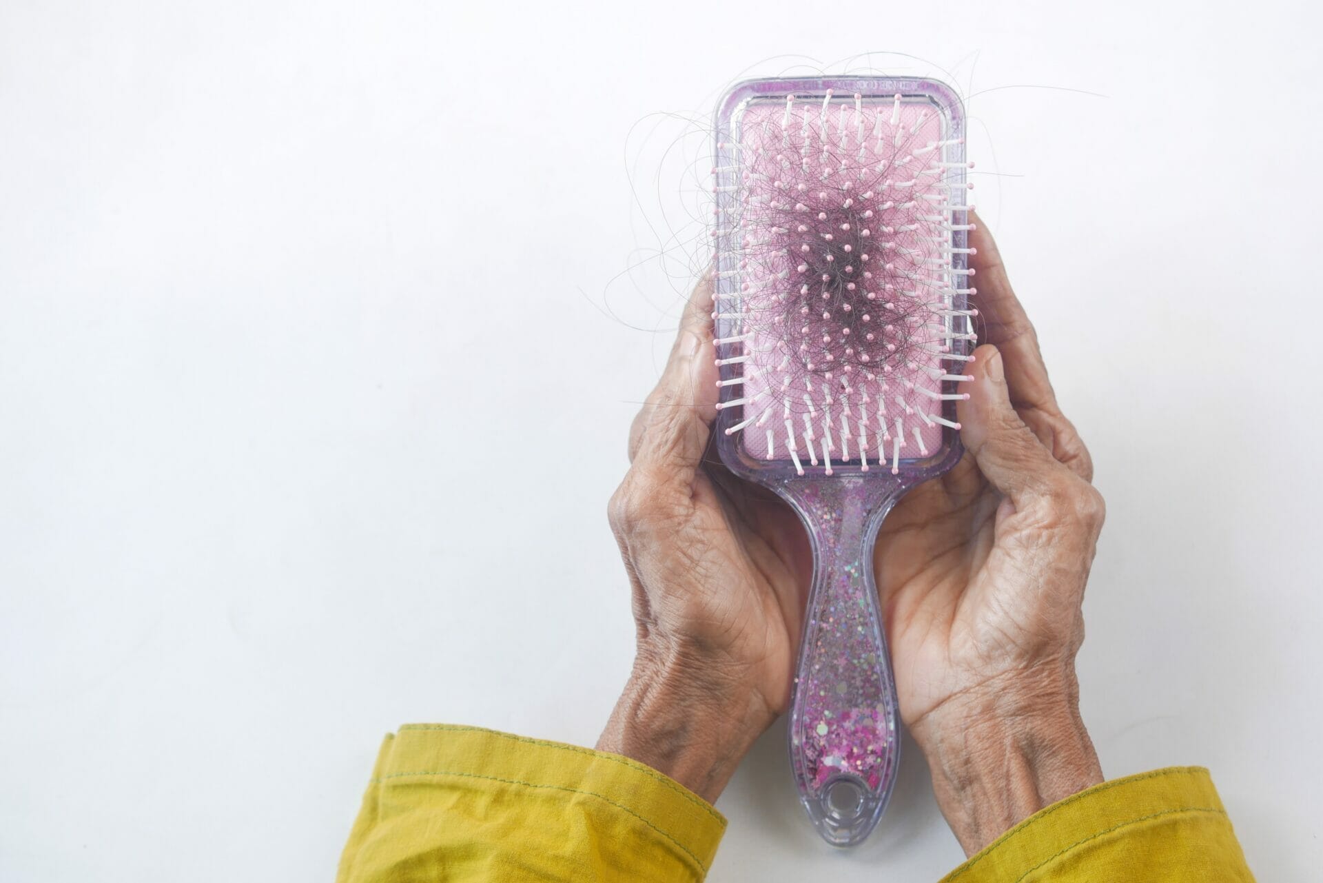 A hair brush held in elderly hands